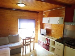 Salón con cocina abierta y paredes de madera