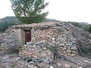 Construcción de piedra seca con puerta de madera