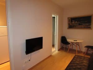 Sala con televisor en la pared y mesa