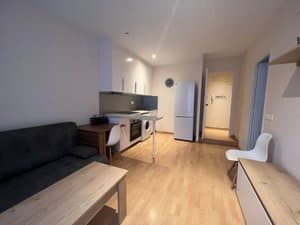 Salón con sofá, cocina y frigorífico