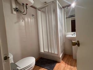 Baño con ducha de mampara e inodoro