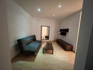 Salón con sofá, mesa baja y espejo