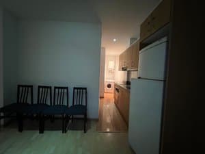 Comedor con sillas y cocina con frigorífico
