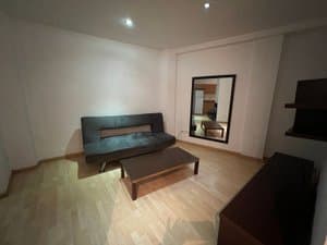 Salón con sofá negro y mueble bajo