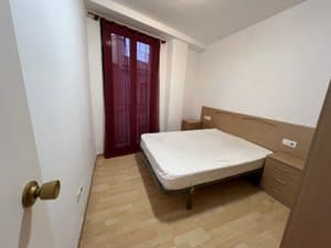 Dormitorio con cama de matrimonio y balcón