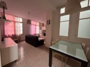 Comedor con mesa de cristal y ventanas