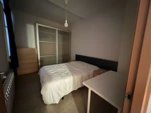 Dormitorio con cama de matrimonio y escritorio