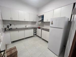 Cocina con muebles blancos y frigorífico