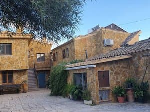 Casa de piedra con patio empedrado y escalera exterior