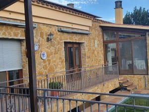 Terraza con barandilla junto a la fachada de piedra