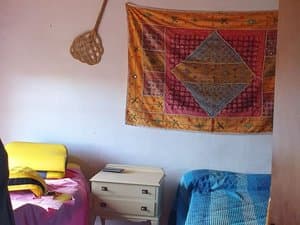 Dormitorio con dos camas y tapiz en la pared