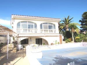 Chalet blanco con balaustrada y piscina cubierta