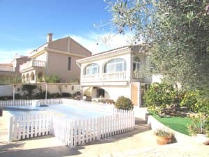 Jardín con piscina cubierta y valla blanca