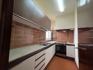 Cocina con muebles oscuros y cocina de gas