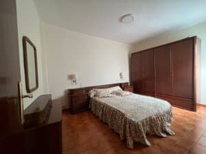 Dormitorio de matrimonio con armario de madera