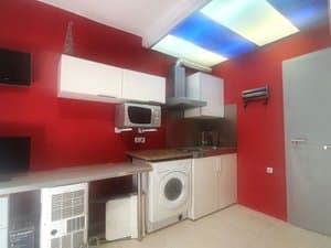 Cocina con pared roja y campana