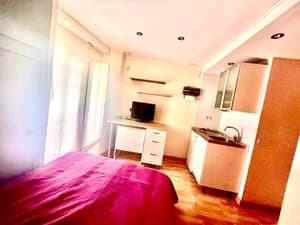Estudio con cama, escritorio y televisor