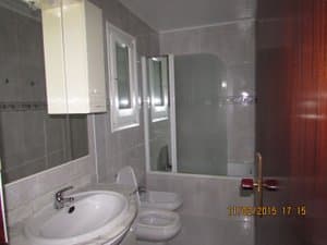Baño con lavabo y bañera de mampara