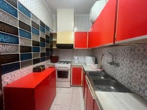 Cocina con muebles rojos y cocina de gas