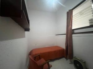 Dormitorio con cama y ventana alta