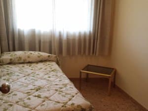 Dormitorio con cama individual y mesita
