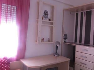 Dormitorio con escritorio y estanterías