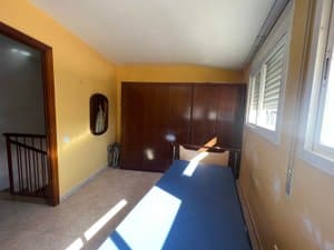 Dormitorio con armario y escalera al fondo