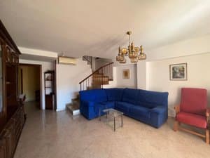 Salón con sofá azul y escalera de caracol