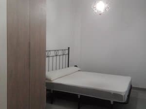 Dormitorio con cama de forja y armario