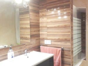 Baño con lavabo y paredes de madera