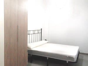 Dormitorio con cama de forja y armario