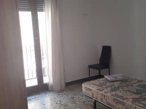 Dormitorio con cama y puerta balconera