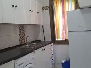 Cocina con lavadora y frigorífico