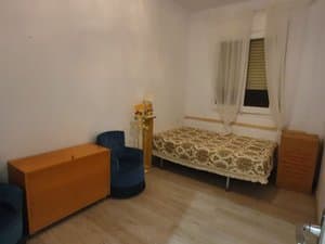 Dormitorio con cama y butaca azul