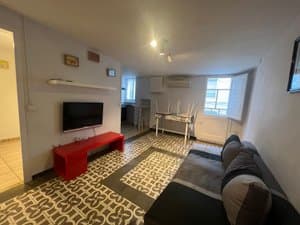 Salón con sofá, televisor y mueble rojo
