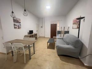 Salón comedor con sofá gris y mesa