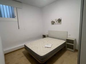 Dormitorio con cama de matrimonio y mesitas