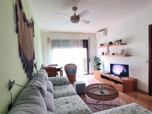 Salón con sofá gris y ventilador de techo