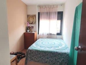 Dormitorio con cama y mesita