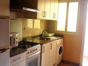 Cocina con cocina de gas, lavadora y microondas