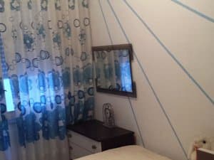 Dormitorio con cortinas y cómoda