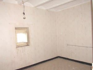 Dormitorio vacío con ventana pequeña