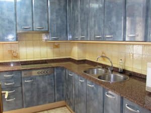 Cocina con muebles azules y fregadero