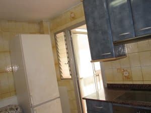 Cocina con frigorífico y salida a la galería