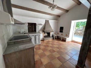 Cocina comedor con chimenea y vigas de madera