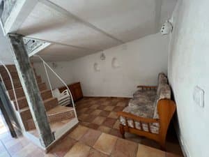 Sala con escalera al altillo y sofá