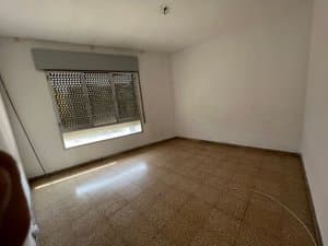 Dormitorio vacío con ventana amplia