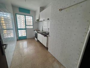 Cocina alargada con muebles blancos