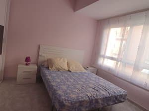 Dormitorio con cama y mesitas