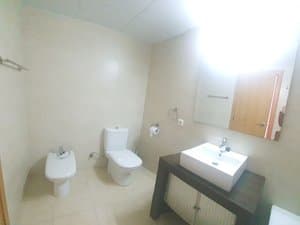 Baño con bidé, inodoro y lavabo sobre mueble